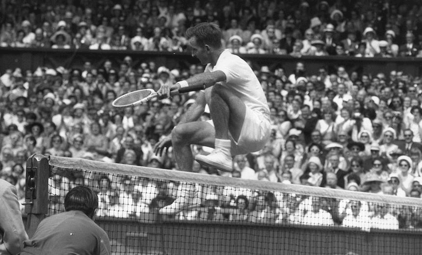 Australia’s Rod Laver leaps over the net at Wimbledon after beating Chuck McKinley of the USA, July 1961. (Photo: Hulton Archive/Getty Images) 
