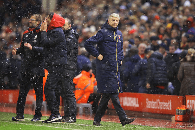 Arsene Wenger's trademark jacket gets a good workout in the snow at Anfield.  (Photo by Alex Livesey/Getty Images)