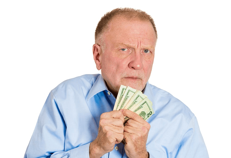 Closeup portrait, greedy senior executive, CEO, boss, old corporate employee, mature man, holding dollar banknotes tightly, isolated white background. Negative human emotion facial expression
