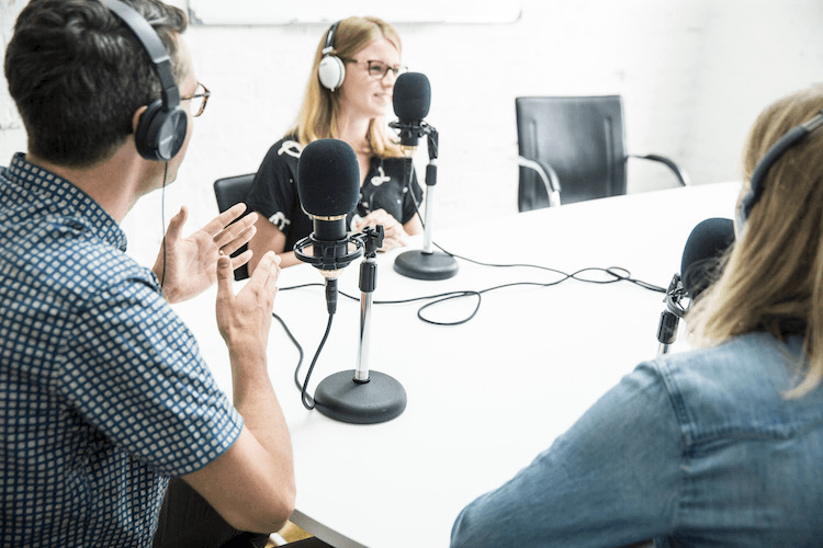 Three Spinoff employees pretending to record a podcast for a photographer