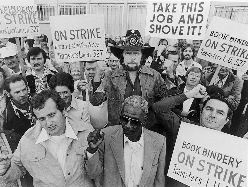 American country singer Johnny Paycheck, of "You Can Take This Job and Shove It" fame, with a group of striking bookbinders, 1977. (Photo by Hulton Archive/Getty Images)