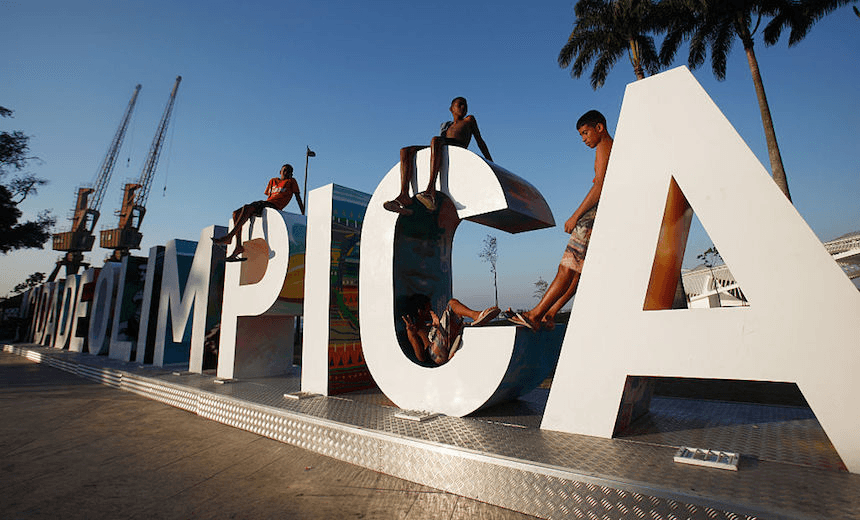 RIO DE JANEIRO, BRAZIL - OCTOBER 15: Teens sit on a new sign reading 'Cidade Olimpica' (Olympic City) in the historic port district on October 15, 2015 in Rio de Janeiro, Brazil. Ahead of the Rio 2016 Olympic Games games, the port district is undergoing a controversial multibillion dollar urban renewal program although some projects have been delayed in the midst of Brazil's recession. Many parts of the port district retain descendants of African slaves along with Afro-Brazilian historical locations including the area where samba music is thought to have been born in Rio. (Photo by Mario Tama/Getty Images)