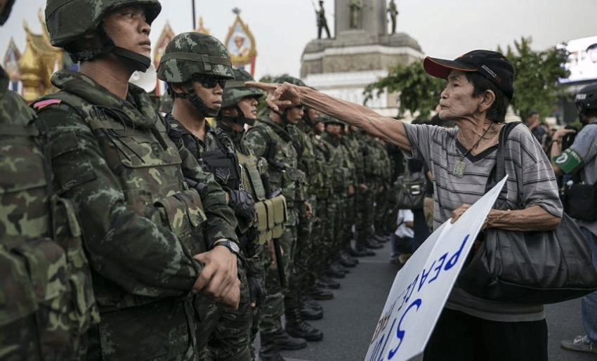 BANGKOK, THAILAND - MAY 26: A Thai protester points a finger at the Thai military during an anti-coup protests as General Prayuth receives the Royal Endorsement as the military coup leader May 26, 2014 in Bangkok, Thailand. Thailand has seen many months of political unrest and violence which has claimed at least 28 lives. Thailand is known as a country with a very unstable political record, it is now experiencing it's 12th coup with 7 attempted pervious coups. Thailand's coup leaders have detained former Prime Minister Yingluck Shinawatra, along with Cabinet members and other anti-government protest leaders for up to a week. (Photo by Paula Bronstein/Getty Images)