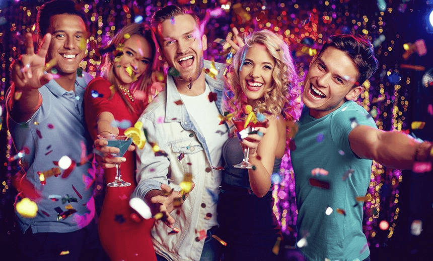 Group of ecstatic friends with cocktails looking at camera at party 
