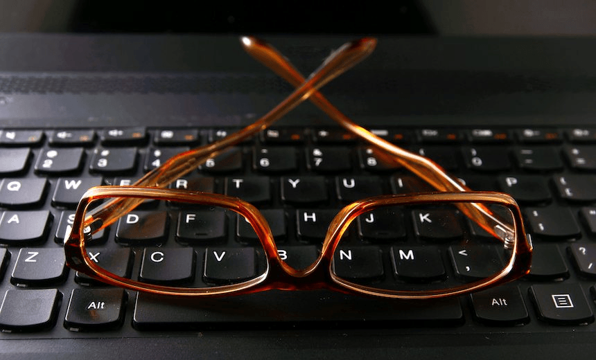 Photo of a pair of eyeglasses on a computer keyboard