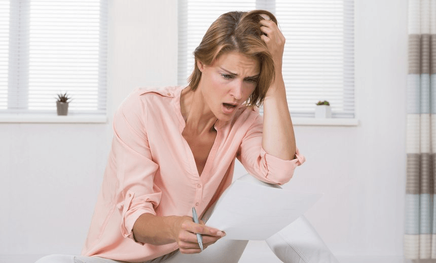 Portrait Of Shocked Young Woman Looking At Paper 
