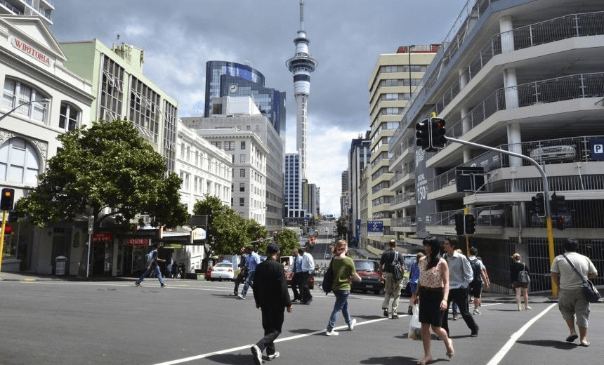 Auckland, New Zealand – February 28, 2012: People walk across the road in Queen Street Auckland New Zealand. 
