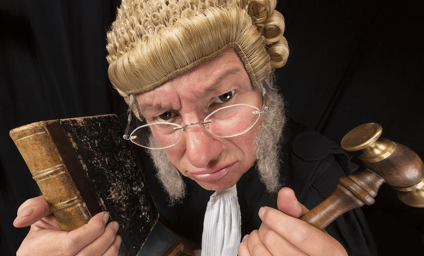 Grumpy old judge in extreme wide angle closeup with hammer and wig 
