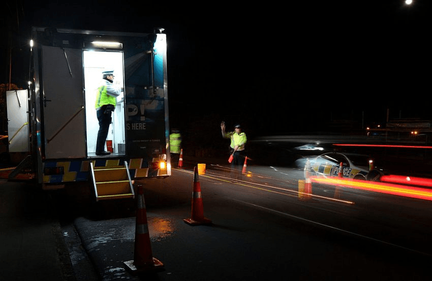 AUCKLAND, NEW ZEALAND - JULY 30: A police officer stops a motorist at a drink driving check point in Penrose on July 30, 2010 in Auckland, New Zealand. The government is implementing a zero-tolerance policy for drivers under 20 and repeat drink-drivers, but will conduct more research before deciding whether to lower the adult alcohol limit from 0.08g of alcohol per 100ml to 0.05g. (Photo by Sandra Mu/Getty Images)