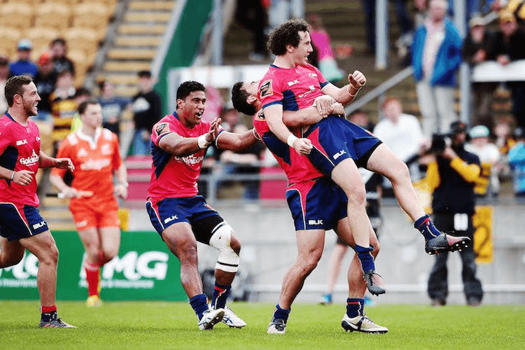Marty Banks' Tasman teammates attempt to physically carry him to a barbershop. (Photo by Anthony Au-Yeung/Getty Images)