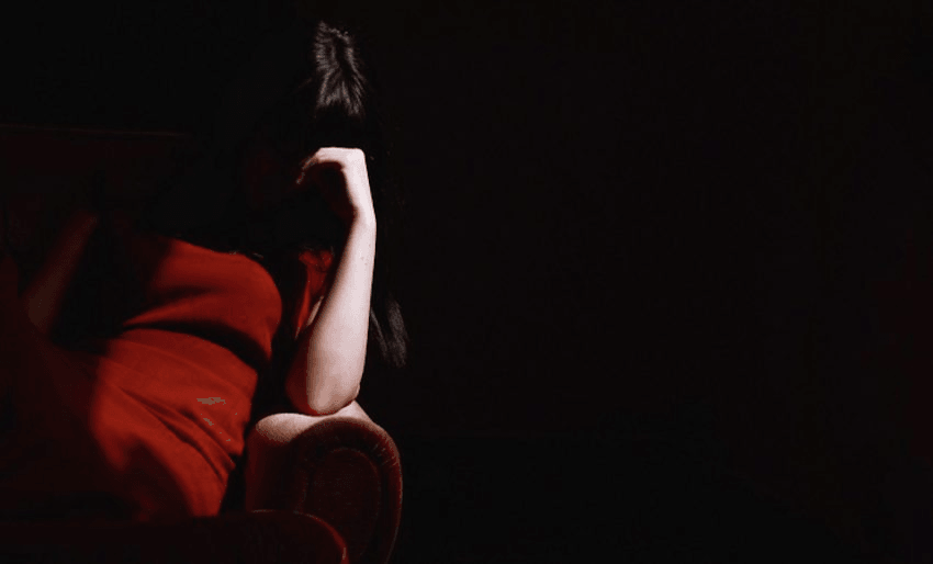 Woman Sitting On Sofa With Head In His Hand