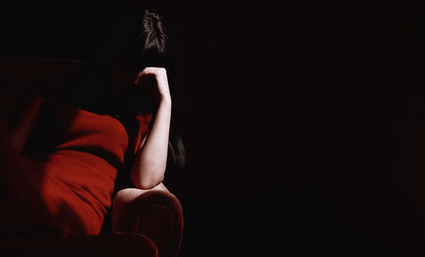 Woman Sitting On Sofa With Head In His Hand