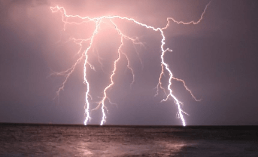 Three strikes of lightning at open sea.