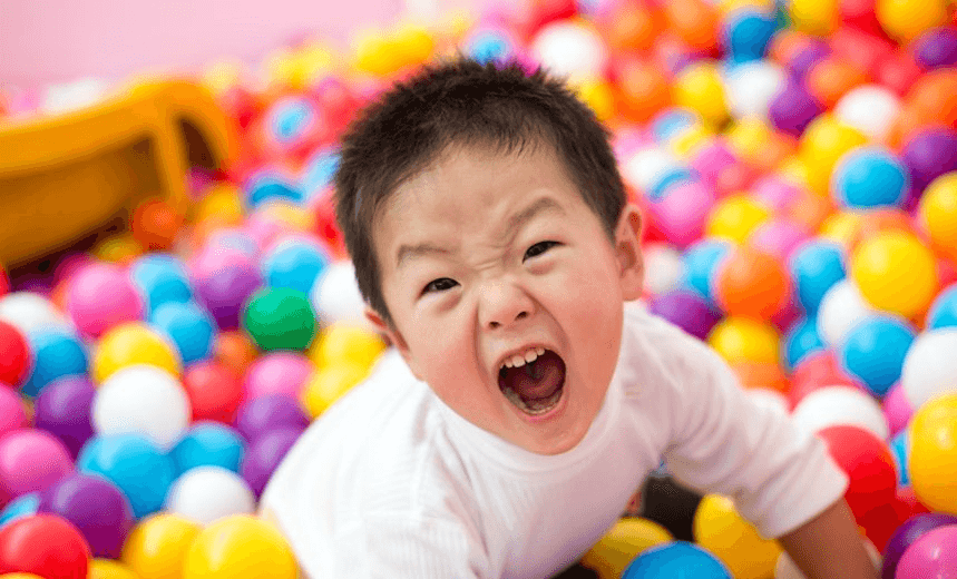 Two year old boy on the ball pool. 
