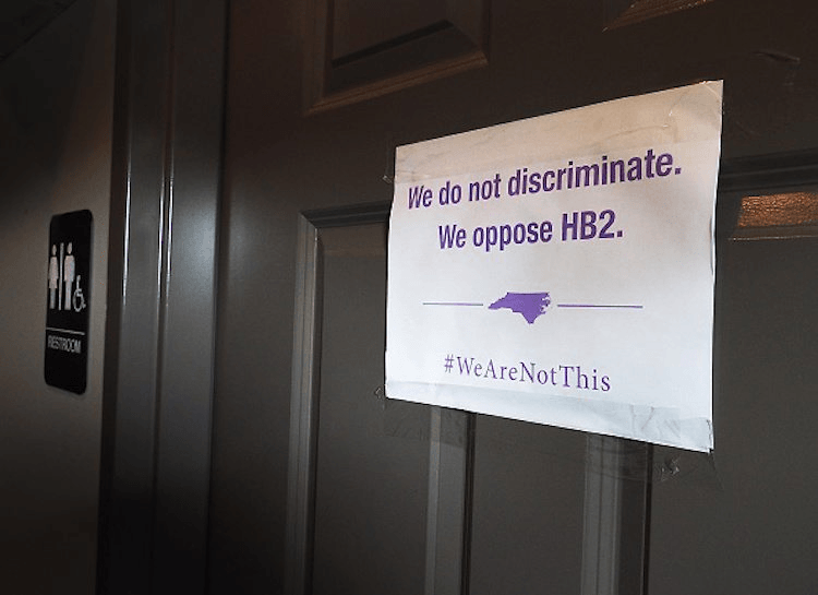 A unisex sign and the anti-bathroom bill "We Are Not This" slogan outside a bathroom in Durham, North Carolina. (Photo by Sara D. Davis/Getty Images)