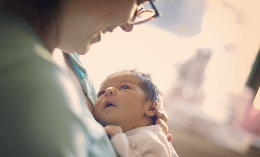 Mom smiling at newborn at hospital