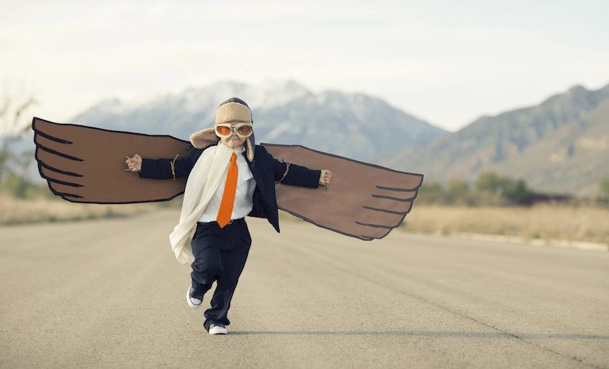 Young Boy Businessman Dressed in Suit with Cardboard Wings