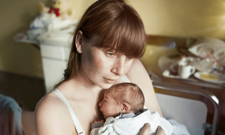 Mother holding her newborn baby in hospital room
