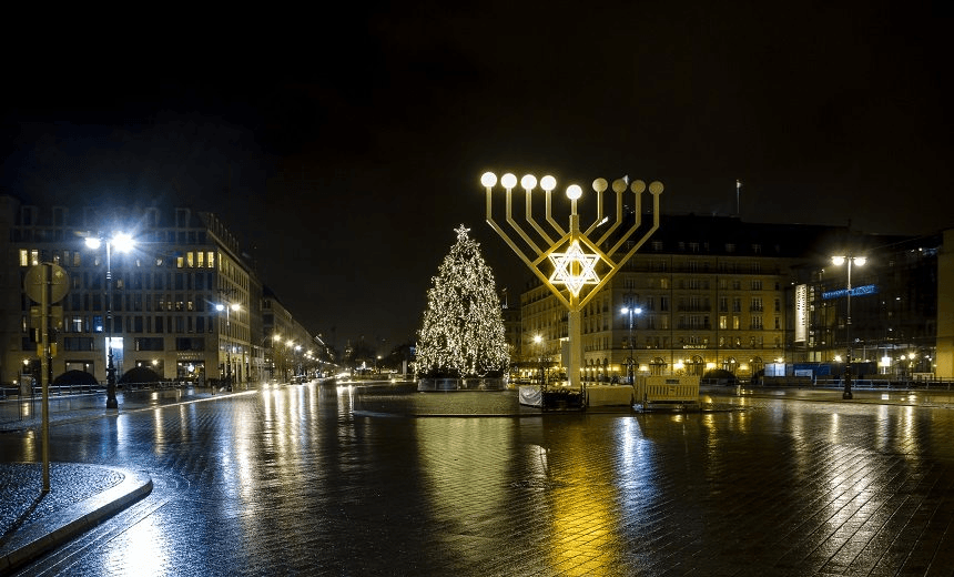 A giant Christmas tree and Hanukkah menorah near the Brandenburg Gate, Berlin.  
