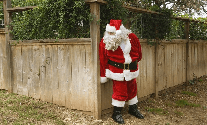 Santa hiding behind fence