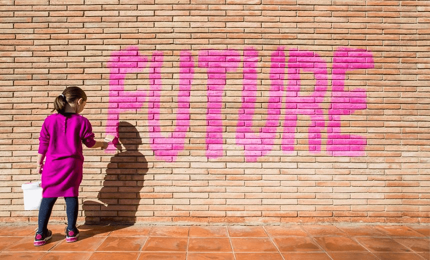 Little girl painting with pink colors the future word in a brick wall, a protest action claiming for future to the new generations.