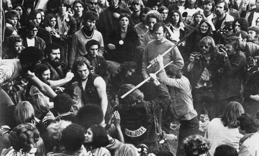 A still from the documentary film ‘Gimme Shelter’, showing audience members looking on as Hells Angels beat a fan with pool cues at the Altamont Free Concert, Altamont Speedway, California, 6th December 1969. The concert was headlined and organized by The Rolling Stones. The film was directed by Albert Maysles, David Maysles and Charlotte Zwerin. (Photo by Bill Owens/20th Century Fox/Hulton Archive/Getty Images) 
