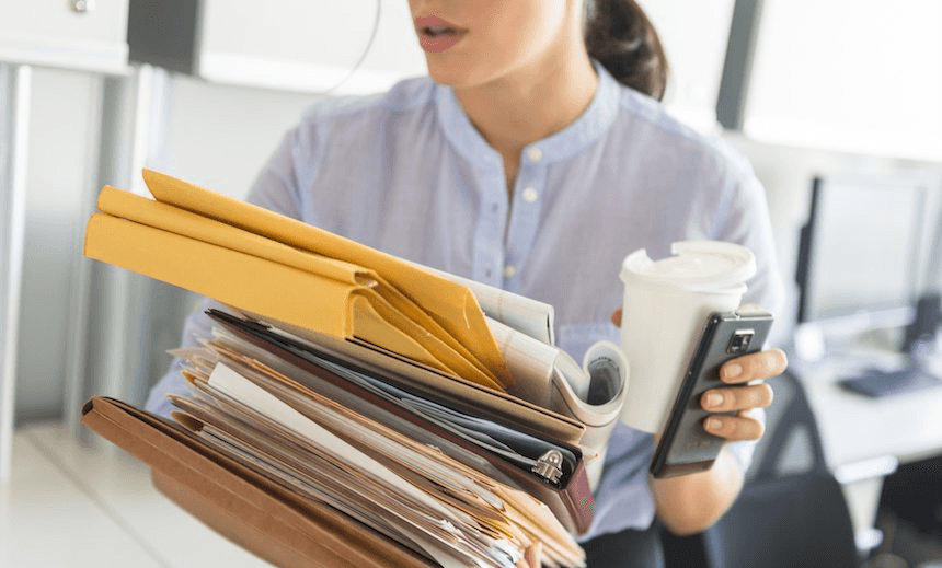 USA, New Jersey, Jersey City, Business woman holding stack of documents in office