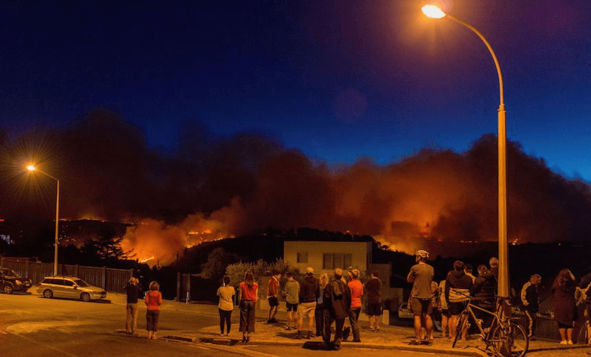 Members of the public look on as smoke and fire light up on February 15, 2017 in Christchurch, New Zealand.  (Photo by Kai Schwoerer/Getty Images) 
