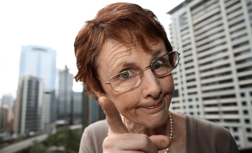 Woman with pointed finger and a dipleased expression. Warped buildings in the background. 
