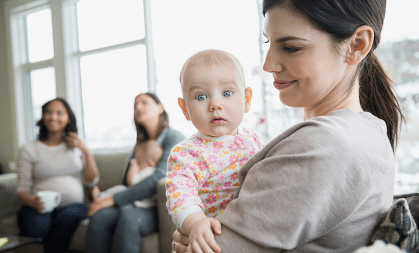Mother holding curious baby in living room