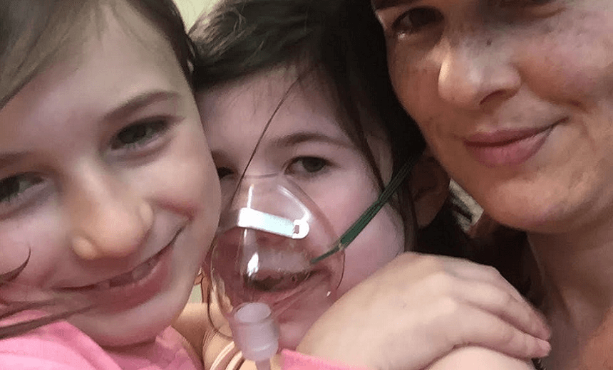 Jessica and her daughters cuddle at the hospital 
