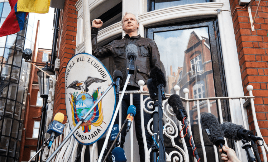 LONDON, ENGLAND – MAY 19: Julian Assange puts his fist in the air as he steps out to speak to the media from the balcony of the Embassy Of Ecuador on May 19, 2017 in London, England. Julian Assange, founder of the Wikileaks website that published US Government secrets, has been wanted in Sweden on charges of rape since 2012. He sought asylum in the Ecuadorian Embassy in London and today police have said he will still face arrest if he leaves. (Photo by Jack Taylor/Getty Images) 
