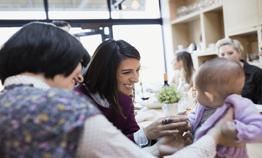 Women playing with baby in restaurant