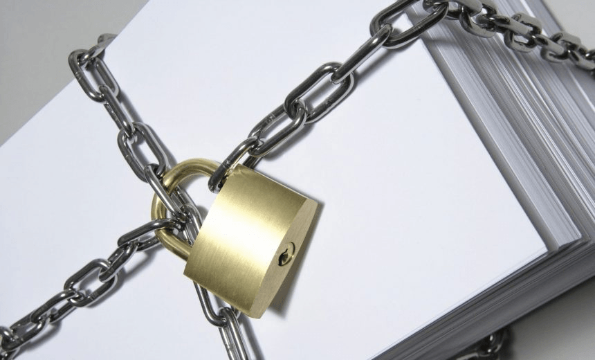 Stack of papers wrapped in chain, close up, white background 
