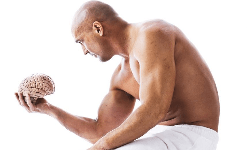 Muscular man ponders a brain he’s holding in his hand. The brain is an anatomically correct medical model. Shot with a Canon EOS 1Ds Mark III and L-series lens. 
