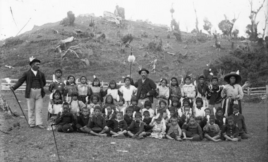 Children from Parihaka Pā with Taare (Charles) Waitara standing centre back. The white feathers show that they are followers of Te Whiti. (Photo: William Andrews Collis/Alexander Turnbull Library) 
