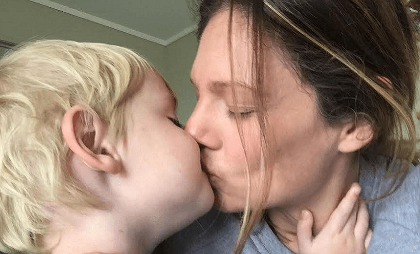 The author Angela kissing one of her sons 
