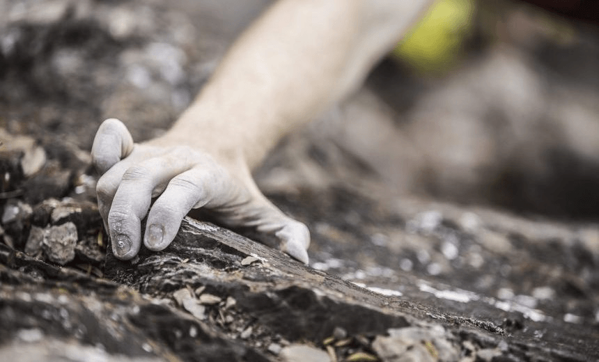 Hand of Caucasian man rock climbing 
