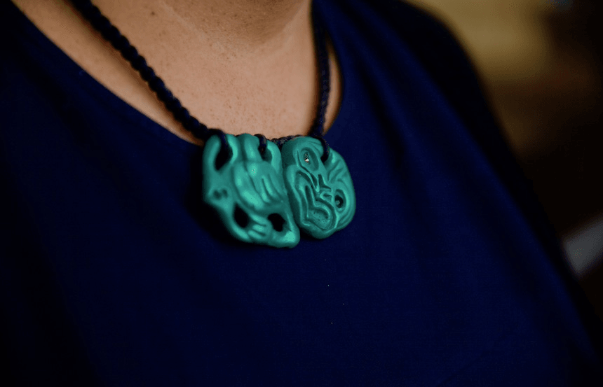 a woman with a hei tiki around her neck in muted colors