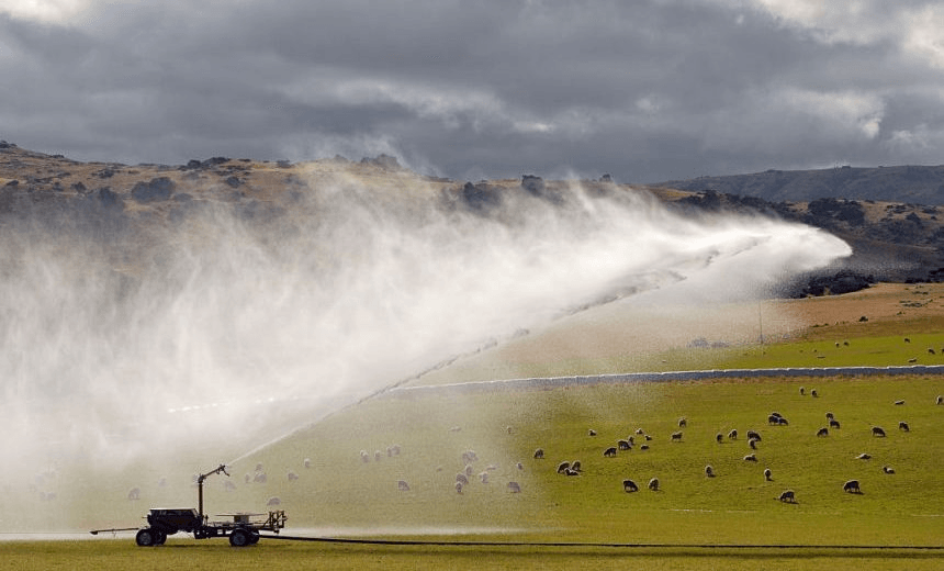 a big irrigator spraying mountain water in the air to try to make the land do something it wouldn't do on its own