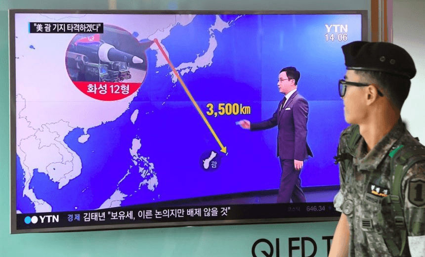 TOPSHOT – A South Korean soldier walks past a television screen showing a graphic of the distance between North Korea and Guam at a railway station in Seoul on August 9, 2017. 
President Donald Trump issued an apocalyptic warning to North Korea on Tuesday, saying it faces “fire and fury” over its missile program, after US media reported Pyongyang has successfully miniaturized a nuclear warhead. / AFP PHOTO / JUNG Yeon-Je        (Photo credit should read JUNG YEON-JE/AFP/Getty Images) 
