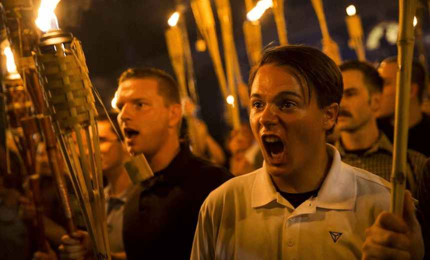 Peter Cvjetanovic (R) along with Neo Nazis and White Supremacists, encircle and chant at the base of a statue of Thomas Jefferson after marching through the University of Virginia campus with torches in Charlottesville, USA on August 11, 2017. (Photo by Samuel Corum/Anadolu Agency/Getty Images)