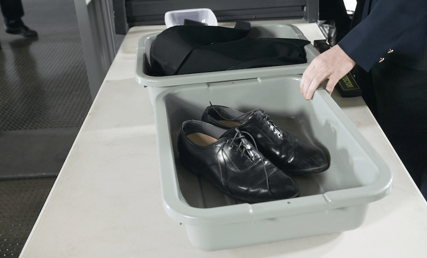 Shoes and Clothes in Containers on a table at Airport Customs 
