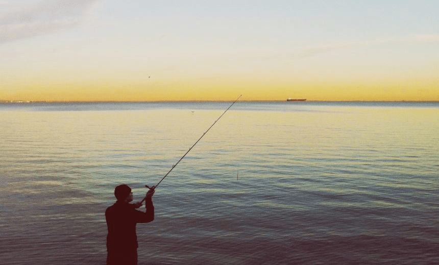 Rear View Of Man Fishing In Lake Against Sky