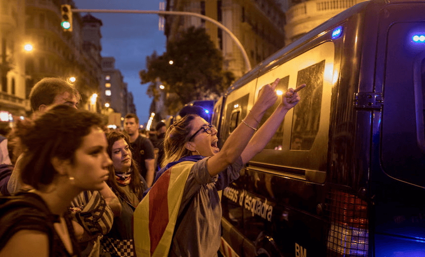 BARCELONA, SPAIN – OCTOBER 02:  A protester pulls the bird at Spanish national police. Image: McGrath/Getty Images. 
