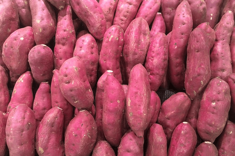A pile of purple coloured kūmara from a bird's eye view.