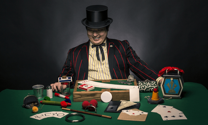 A Japanese magician sitting with some of his props and magic tricks. 
