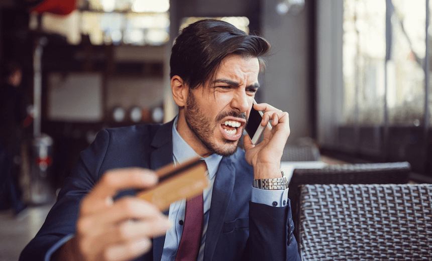 Angry businessman phoning the bank for credit card support. 
