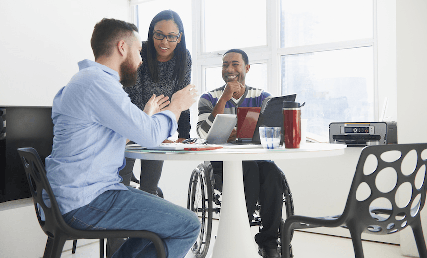 Business people using laptops at table
