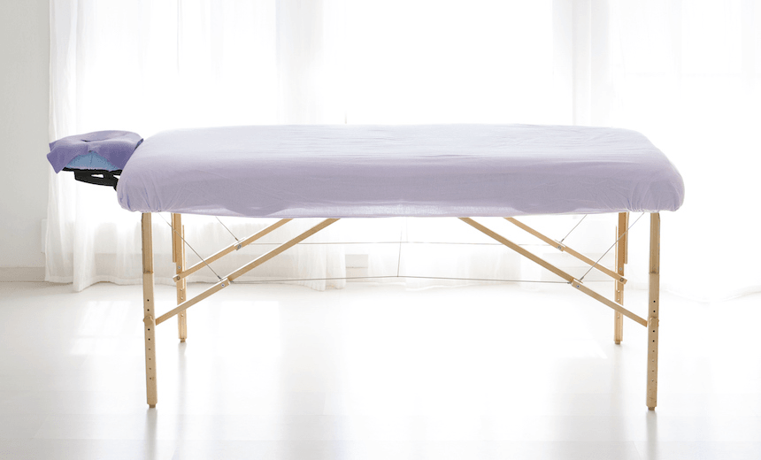 massage table in white room with curtain